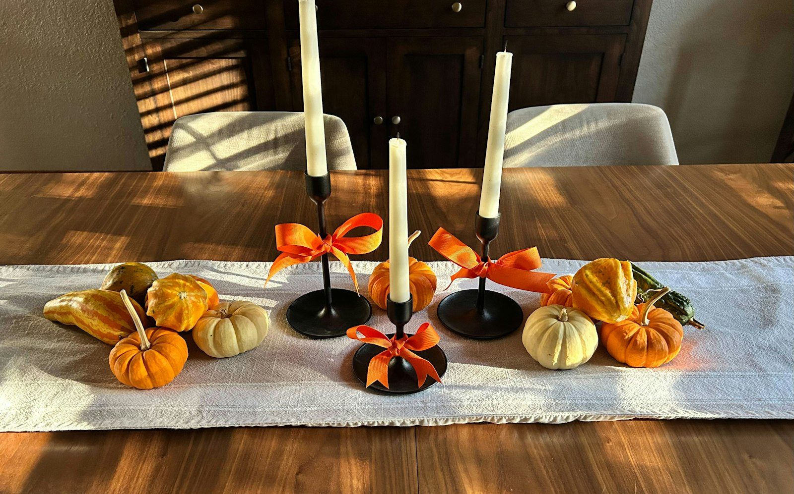 Thanksgiving table centerpiece with pumpkins and candles