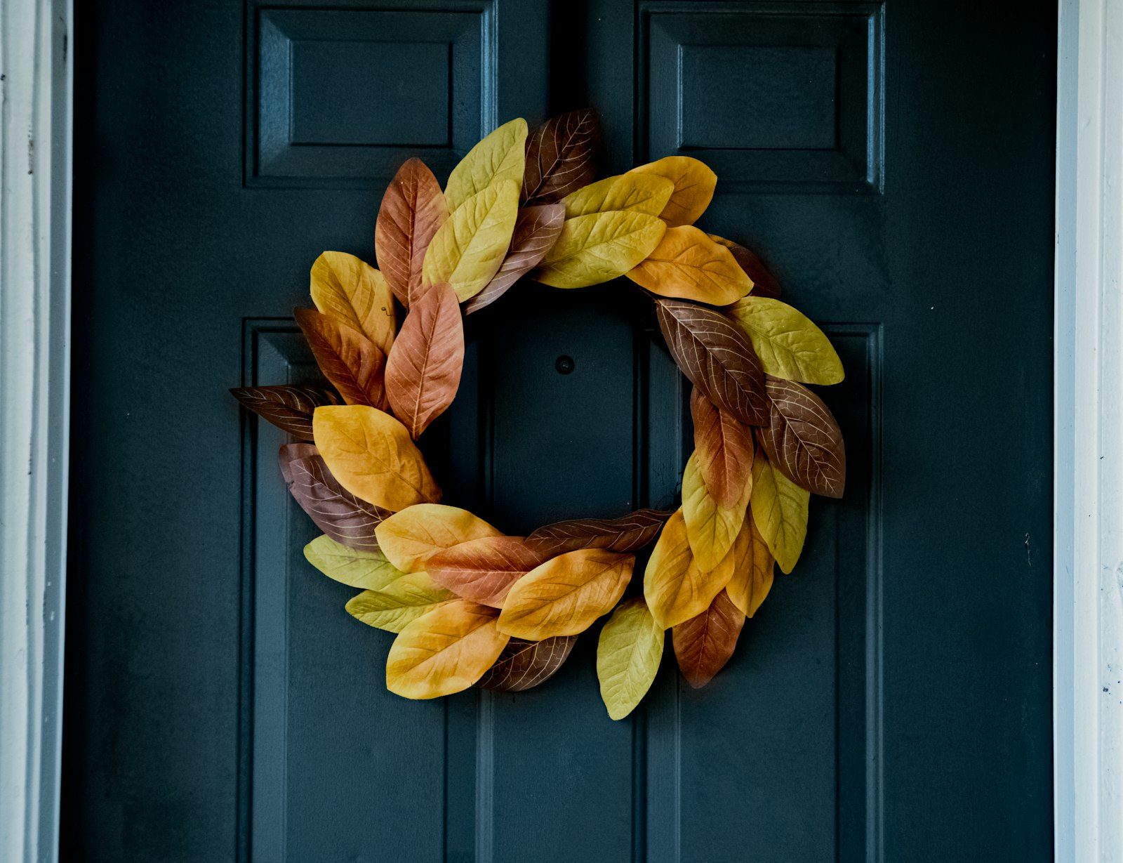 Fall wreath with autumn leaves on front door